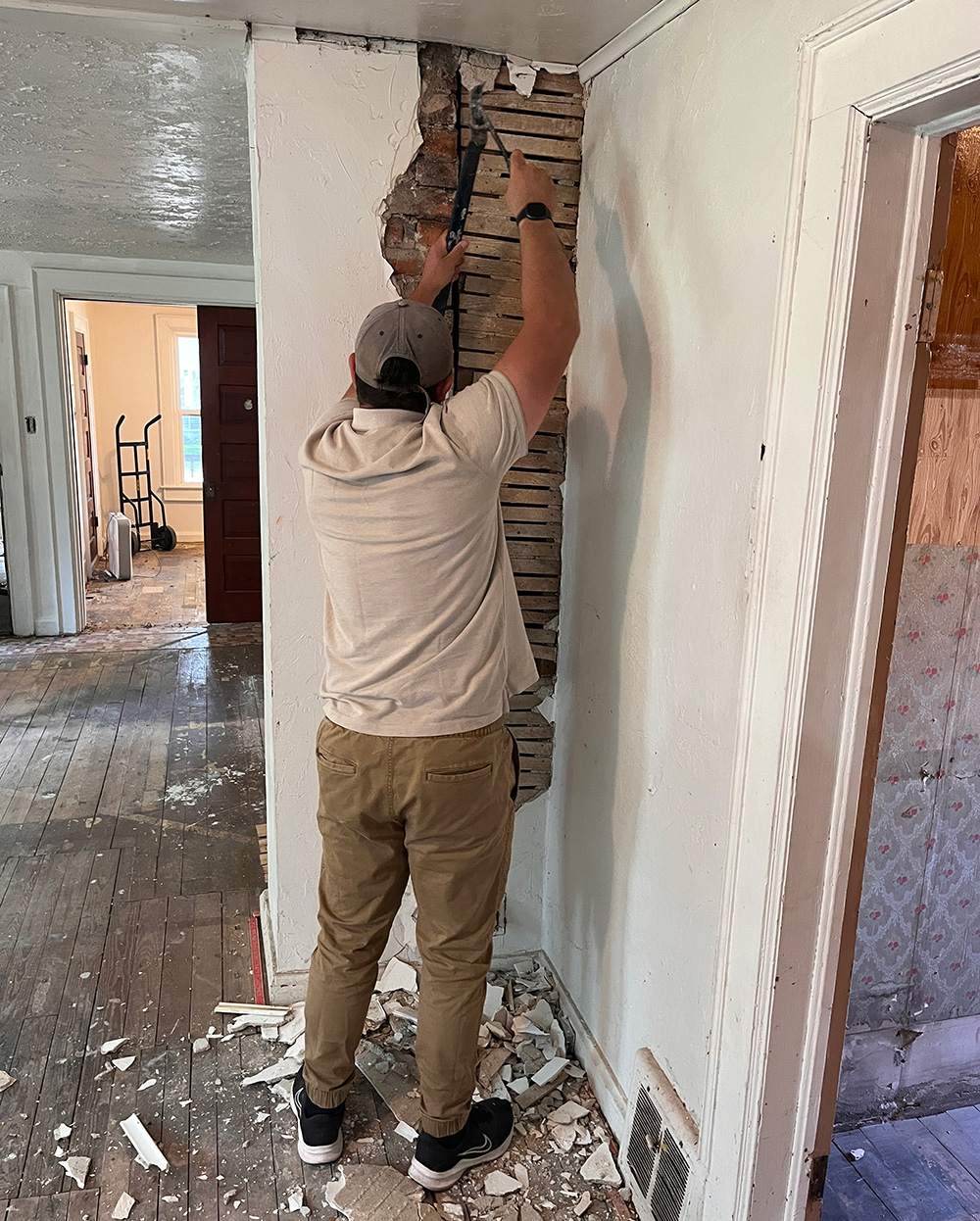 Man demolishing wall in home.